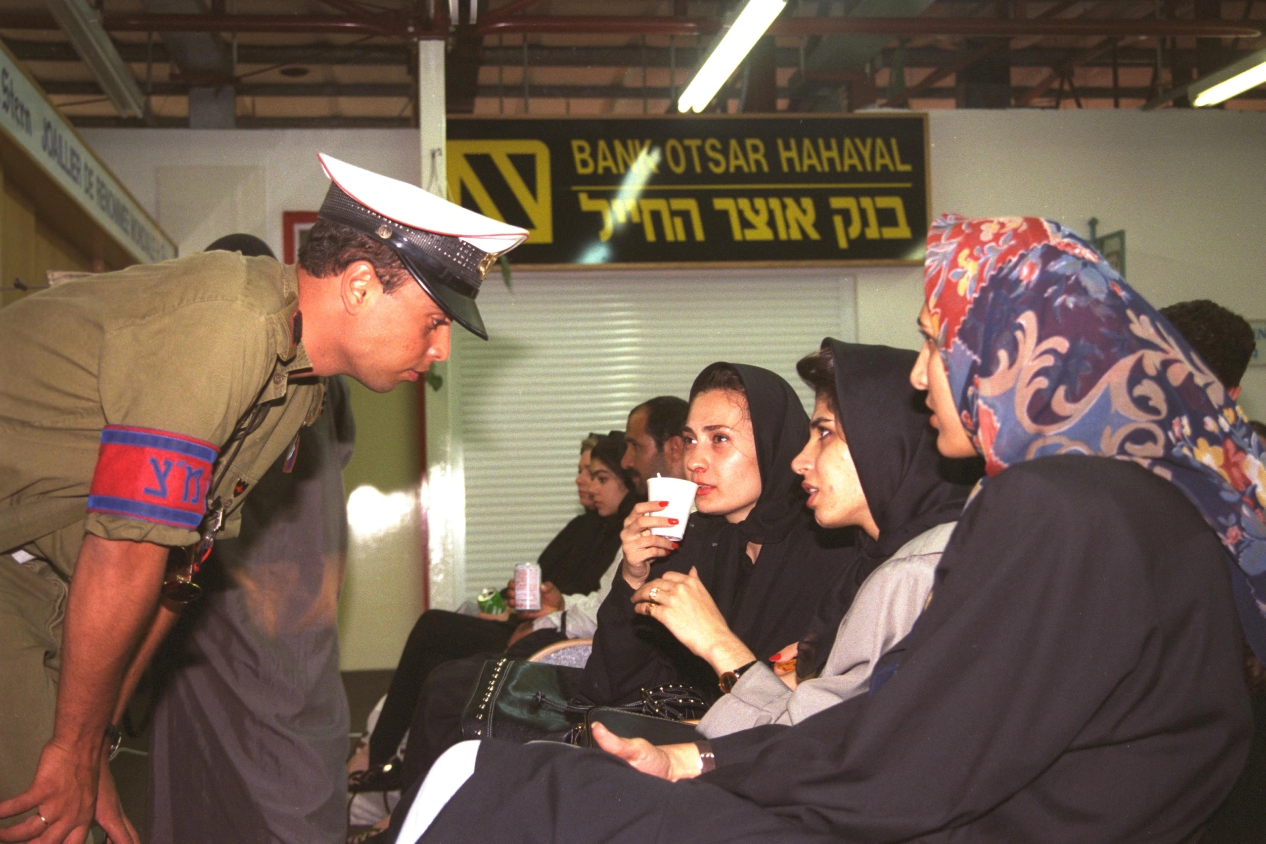 חייל המשטרה הצבאית עוזר לנוסעות המטוס האירני החטוף אשר אולץ לנחות בשדה התעופה בעובדה