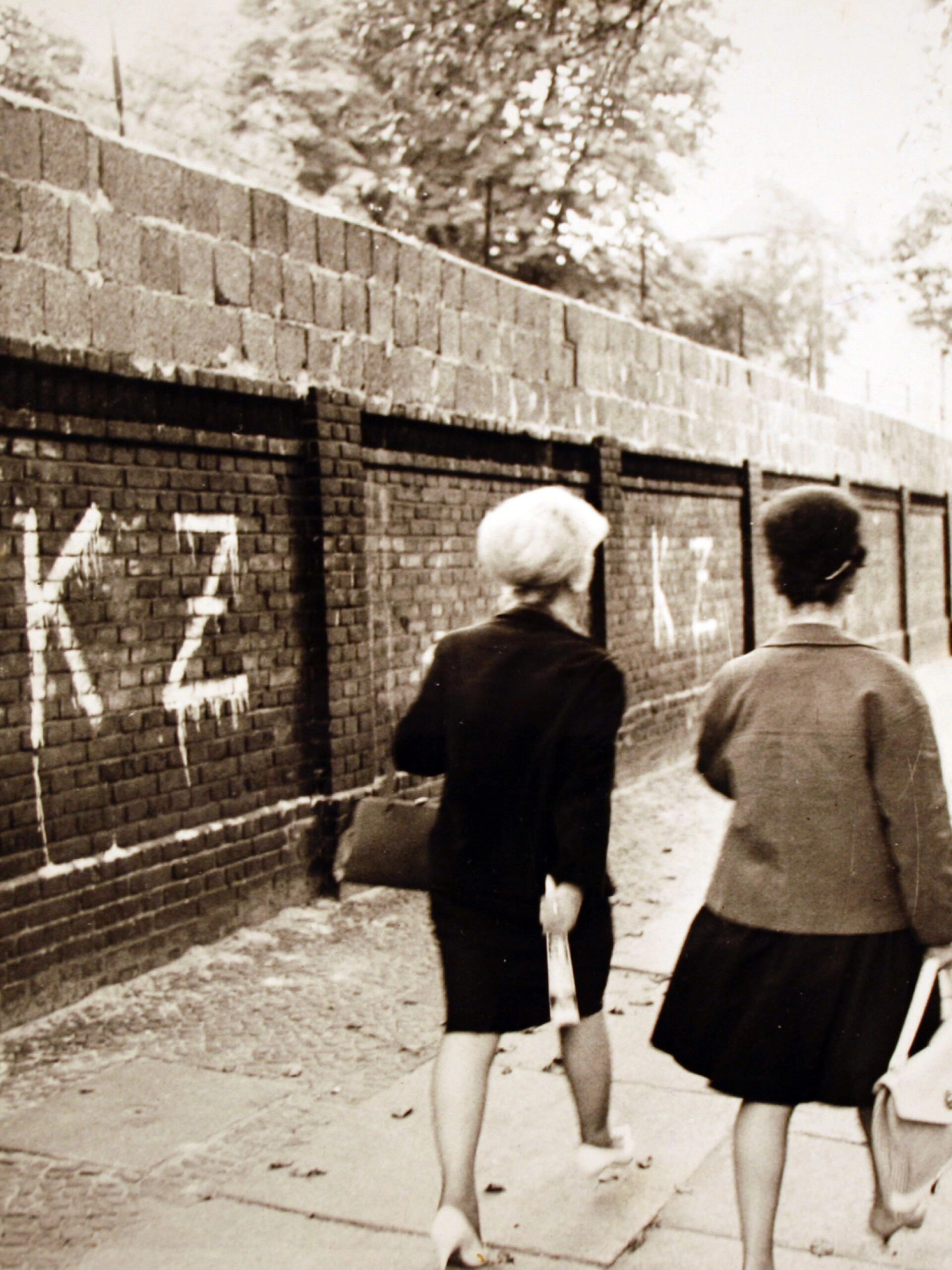 1961. גרפיטי על חומת ברלין. בצד המערבי של חומת ברלין, אותיות הגרפיטי "KZ" מייצגות "Konzentrationslager" או "מחנה ריכוז", דבר המצביע על זלזולו של אמן הגרפיטי בחומה.