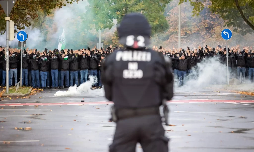 A police officer looks on as Hannover 96 fans march towards their stadium for the game against Eintracht Braunschweig in November. Photograph: Dpa Picture Alliance/Alamy.