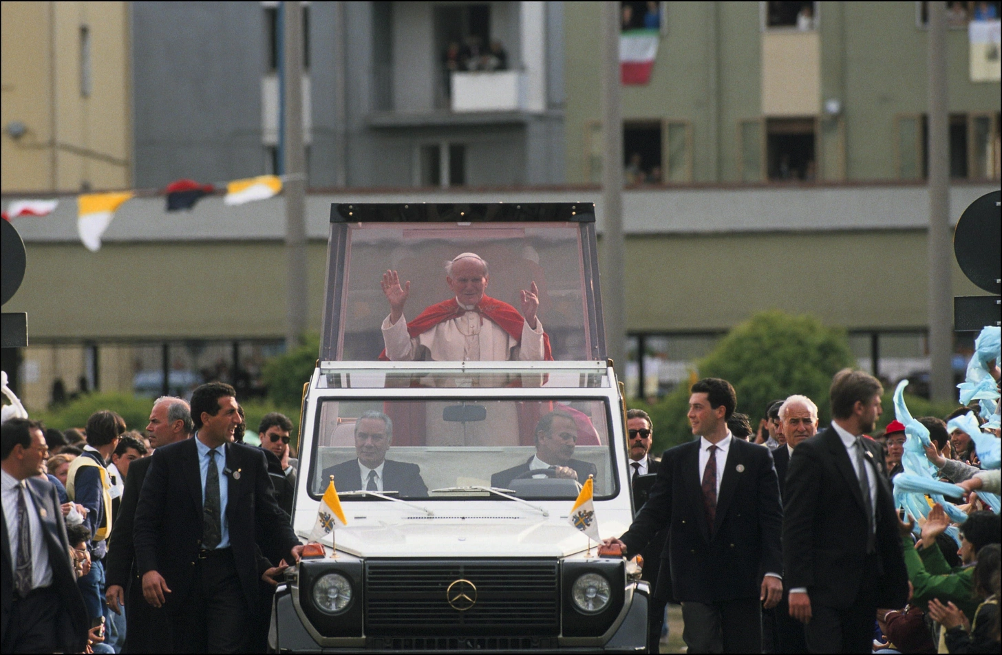 ב-31 במאי 1981, נורה האפיפיור בכיכר פטרוס הקדוש בוותיקן על ידי מהמט עלי אג'ה, חבר בקבוצת הימין הקיצוני הטורקית "הזאבים האפורים". רבים מאמינים שניסיון ההתנקשות בוצע על ידי שירותי הביטחון הבולגריים, בעקבות הוראות ממוסקבה. יהיה אשר יהיה, מאז האפיפיור נוהג ב"פופמוביל" משוריין. מקור: Livio ANTICOLI/Gamma-Rapho via Getty Images.