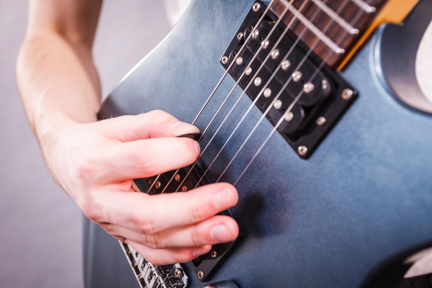 יד פורטת על מיתרי גיטרה חשמלית